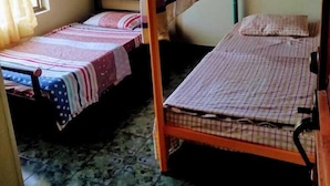 Un dormitorio con dos literas, una ventana con cortinas y piso de baldosas.