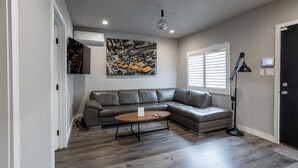 A modern living room with a gray leather sectional sofa, a wooden coffee table, and a black floor lamp. - NEWLY Renovated 2bed/1bath home! (Los Angeles)