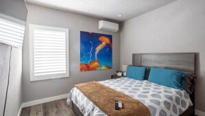 A bedroom with a bed, a painting, a window with blinds, and an air conditioning unit. - NEWLY Renovated 2bed/1bath home! (Los Angeles)