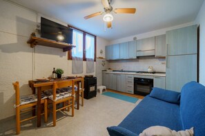 Cozy living space with a kitchenette, dining area, and flat-screen TV.