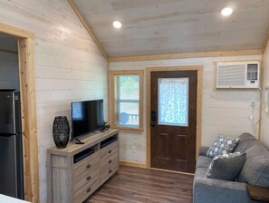 Relax in this cozy space with a flat-screen TV, sofa, and air conditioning for a comfortable stay.