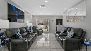 A modern living room with two leather sofas, a coffee table, and a large abstract painting on the wall. - Tampa's Paradise (Tampa)