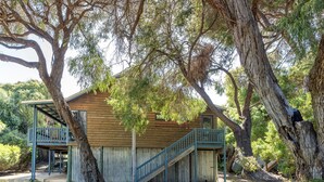 A wooden cabin with a wooden deck and stairs leading to a balcony. - Surfside Retreat | Gnarabup (Gnarabup)