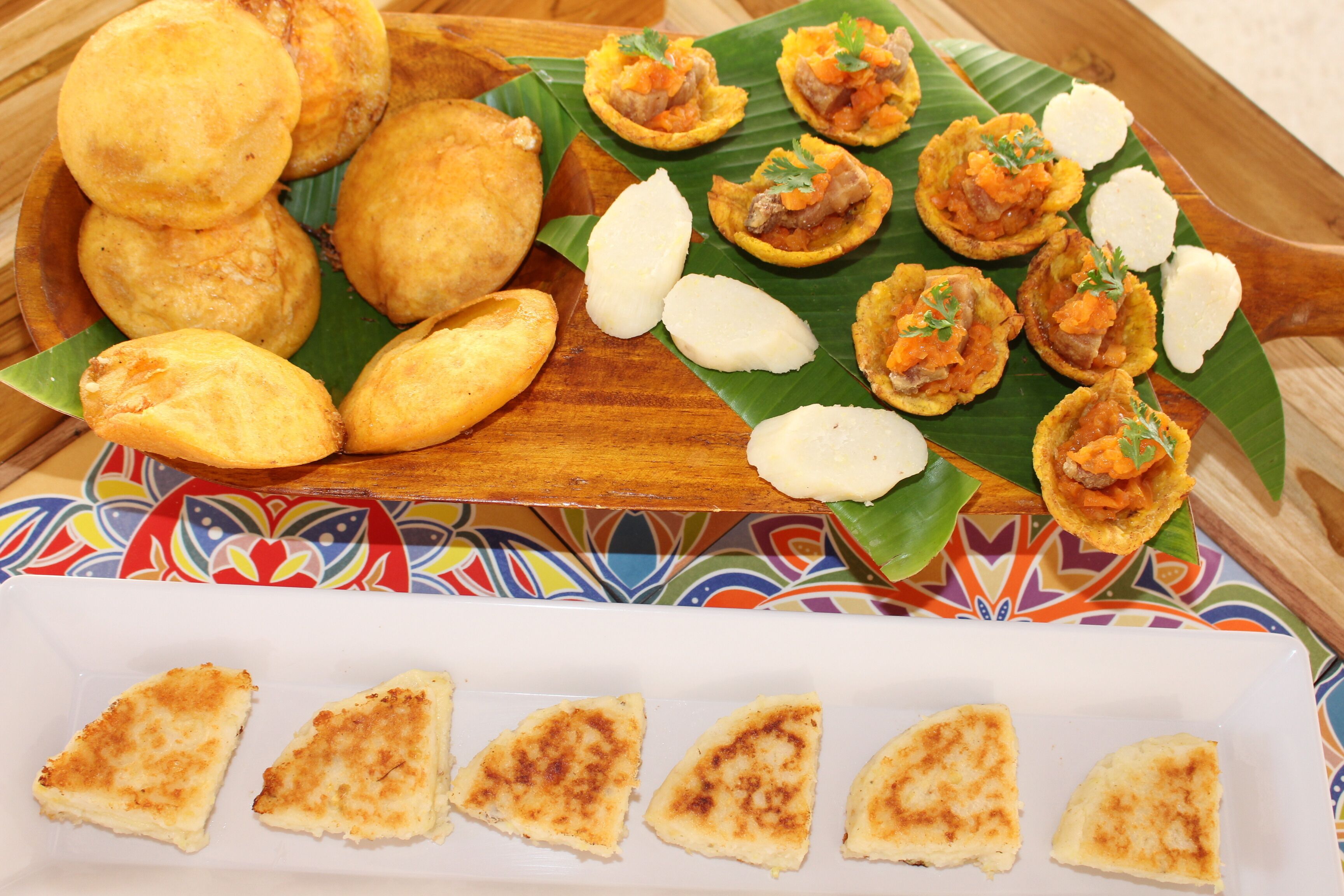 Diversos bocadillos fritos y un plato blanco con porciones triangulares de comida.