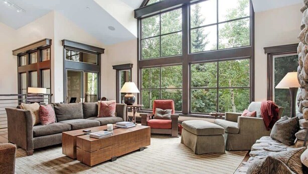 A spacious living room with large windows, a fireplace, and a cozy seating area. - Elegant Beaver Creek Retreat (Beaver Creek)