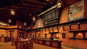 Un restaurant aux murs de briques, aux luminaires suspendus et orné d’une fresque murale.