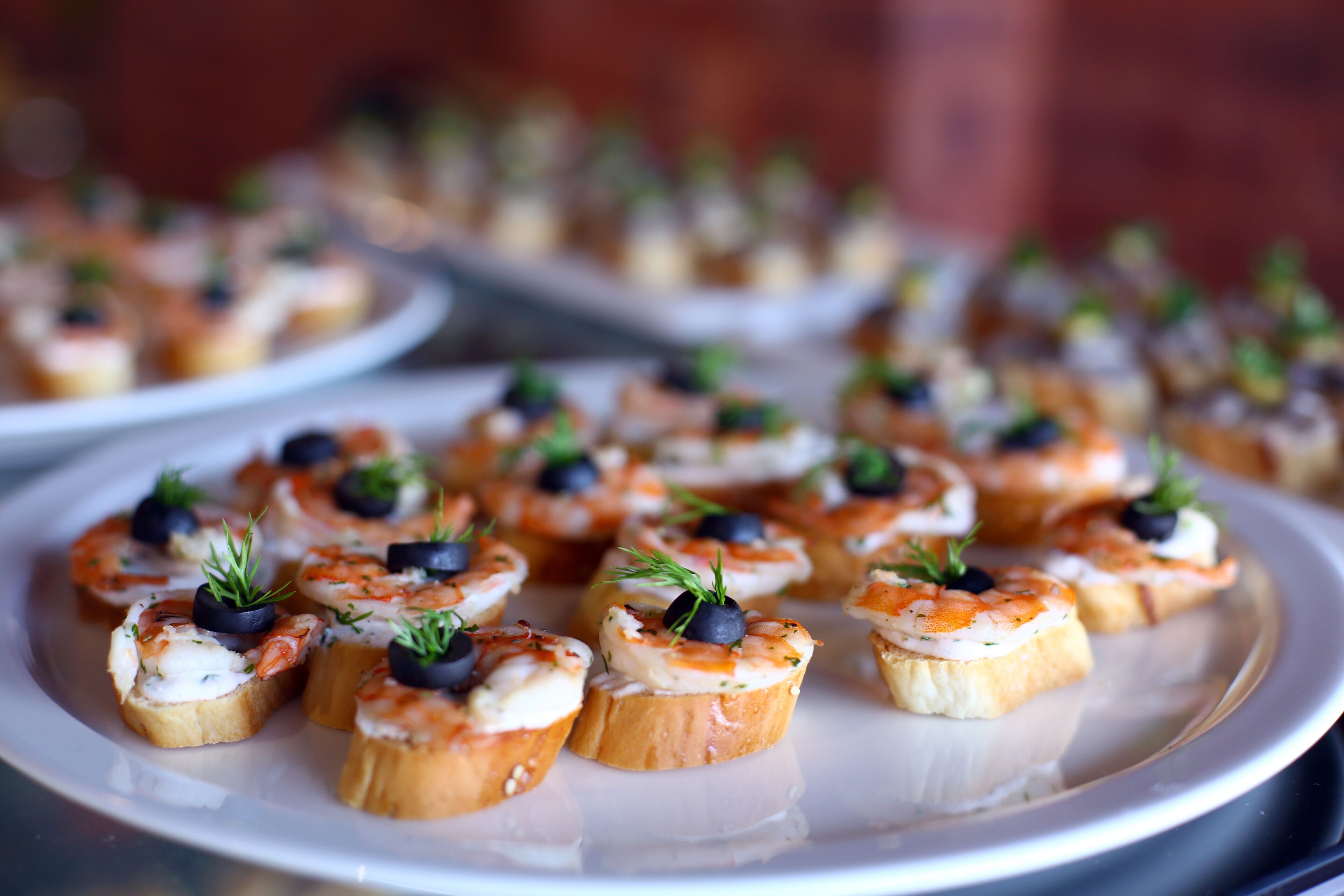 A plate of appetizers with shrimp, cheese, and herbs.
