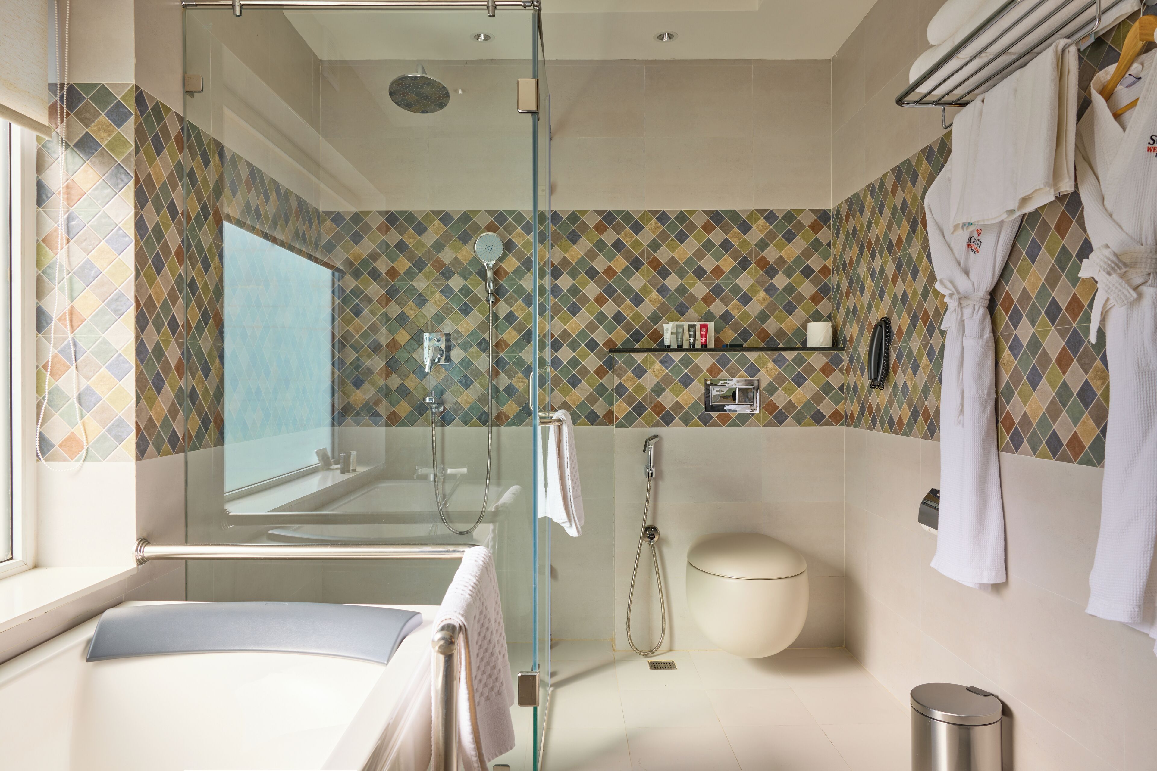 A modern bathroom with a glass shower enclosure, a bathtub, and a toilet.