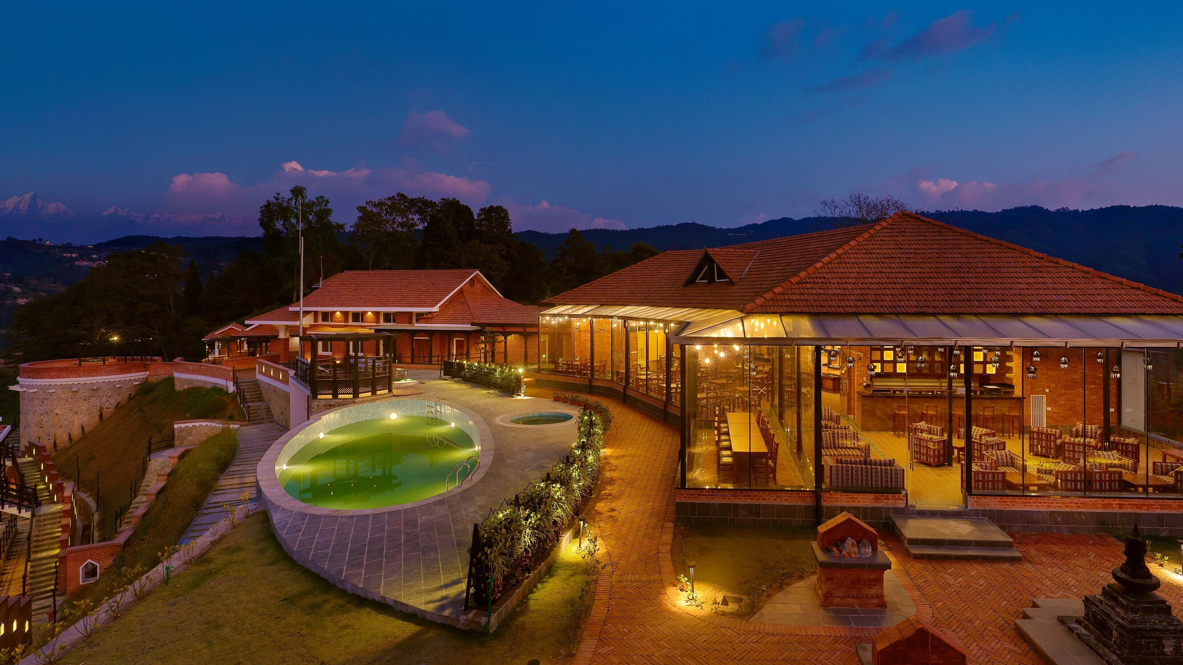 Un resort con piscina, mobiliario exterior y vistas a la montaña.
