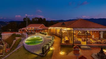 Un resort con piscina, mobiliario exterior y vistas a la montaña.