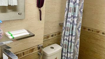 Un baño con inodoro, lavamanos y cortina de ducha.