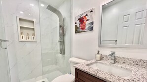 A modern bathroom with a glass-enclosed shower, a toilet, a sink with a granite countertop, and a mirror above the sink. - Renovated Rooms 10-min to Finch Subway Near Yonge St (Toronto)