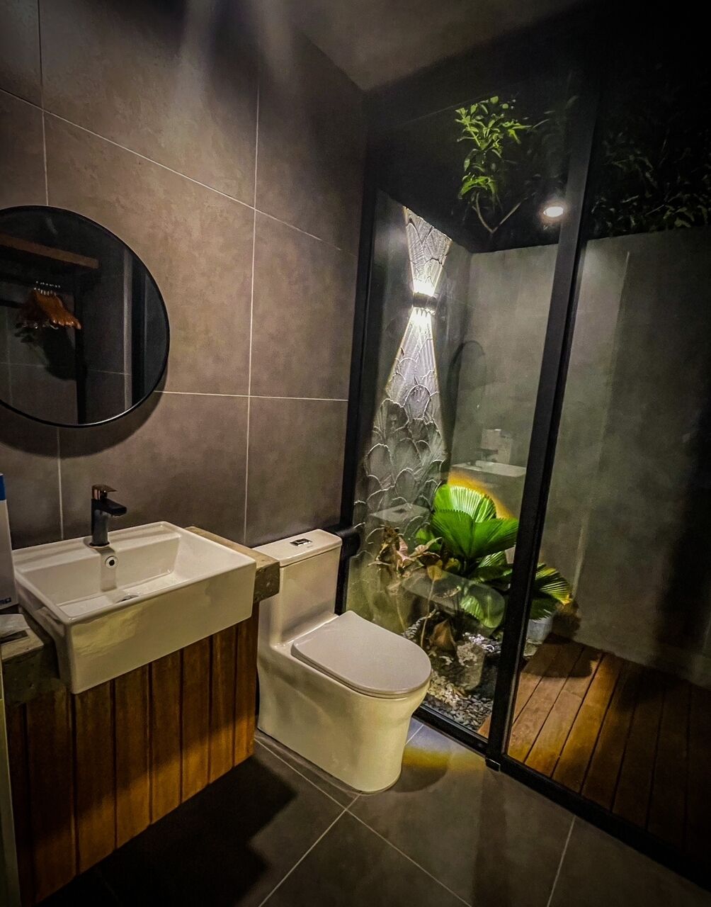 Ein modernes Badezimmer mit Toilette, Waschbecken und Duschbereich.