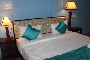 Restful retreat with a tufted headboard and two comfortable beds, each with a bedside table and lamp.