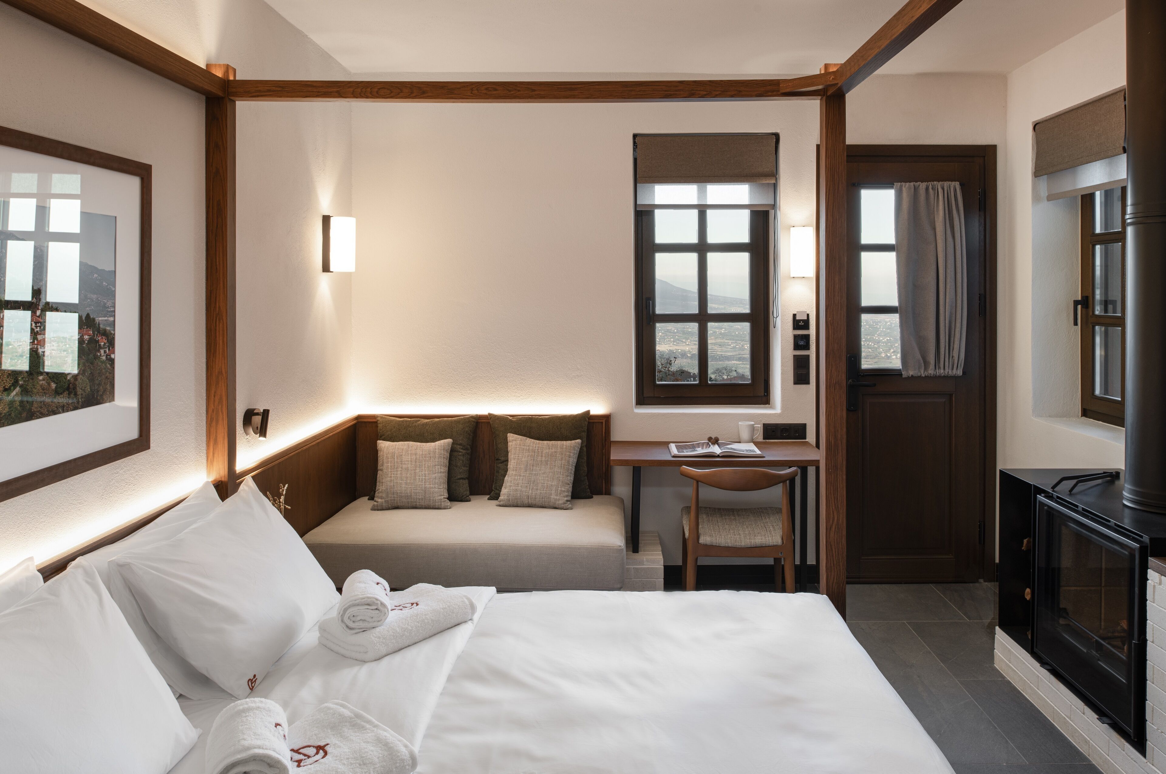 Habitación de hotel con cama, escritorio, silla, televisor y ventana con vistas.