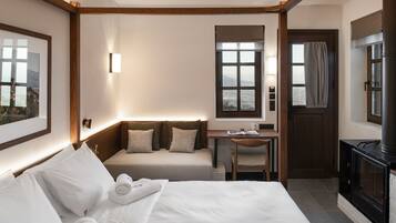 Habitación de hotel con cama, escritorio, silla, televisor y ventana con vistas.
