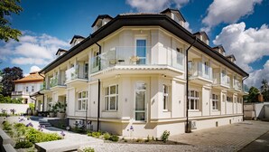 A multi-story building with balconies, large windows, and a garden area. - Hotel U Kaplicky (Pisek)