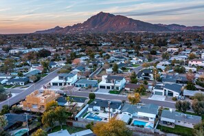 Área residencial com casas, piscina e montanha ao fundo.