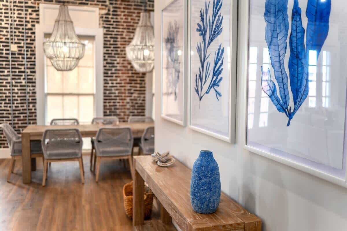 Un comedor con pared de ladrillo, mesa de madera y sillas.