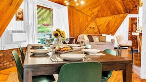 A dining area with a wooden table set for four, surrounded by green chairs. - Unique Dome with HotTub & Mtn Views (Bryant Pond)