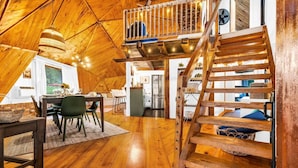 A spacious loft with a wooden interior, a dining area, and a staircase. - Unique Dome with HotTub & Mtn Views (Bryant Pond)