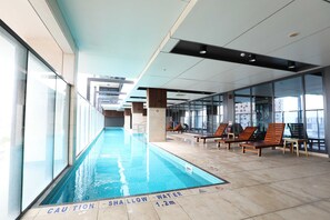 Relax by the pool with lounge chairs and sun loungers, surrounded by a modern design.