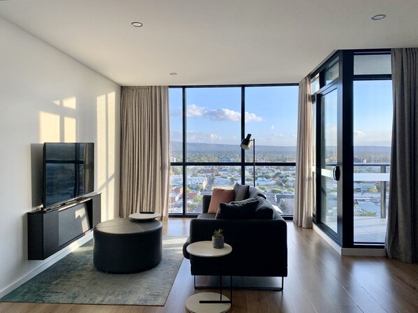 Relax in comfort with a panoramic city view, a comfortable sofa, and a flat-screen TV.