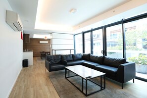 Relax in this stylish living space with a large sofa, coffee table, and dining area.