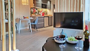 Eine moderne Küche mit Flachbildfernseher, Esstisch und Stühlen.