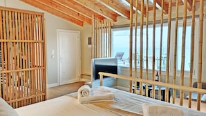 Ein Zimmer mit Bett, Fernseher und Meerblick.