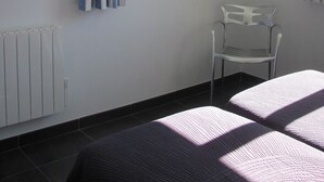 A room with a bed, a chair, a radiator, a window with curtains, and a framed picture on the wall. - NICE APARTMENT IN HAMLET 700 M / north pond, fiber, solar hot water (Santa-Lucia-Di-Mercurio)