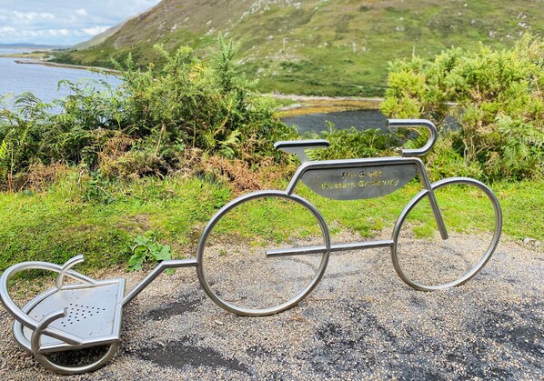 Escultura de bicicleta de metal con una placa que reza