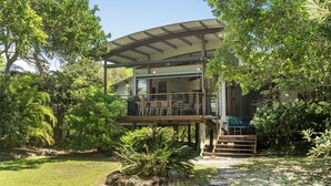 Ein modernes Haus mit überdachter Terrasse, umgeben von üppigem Grün.