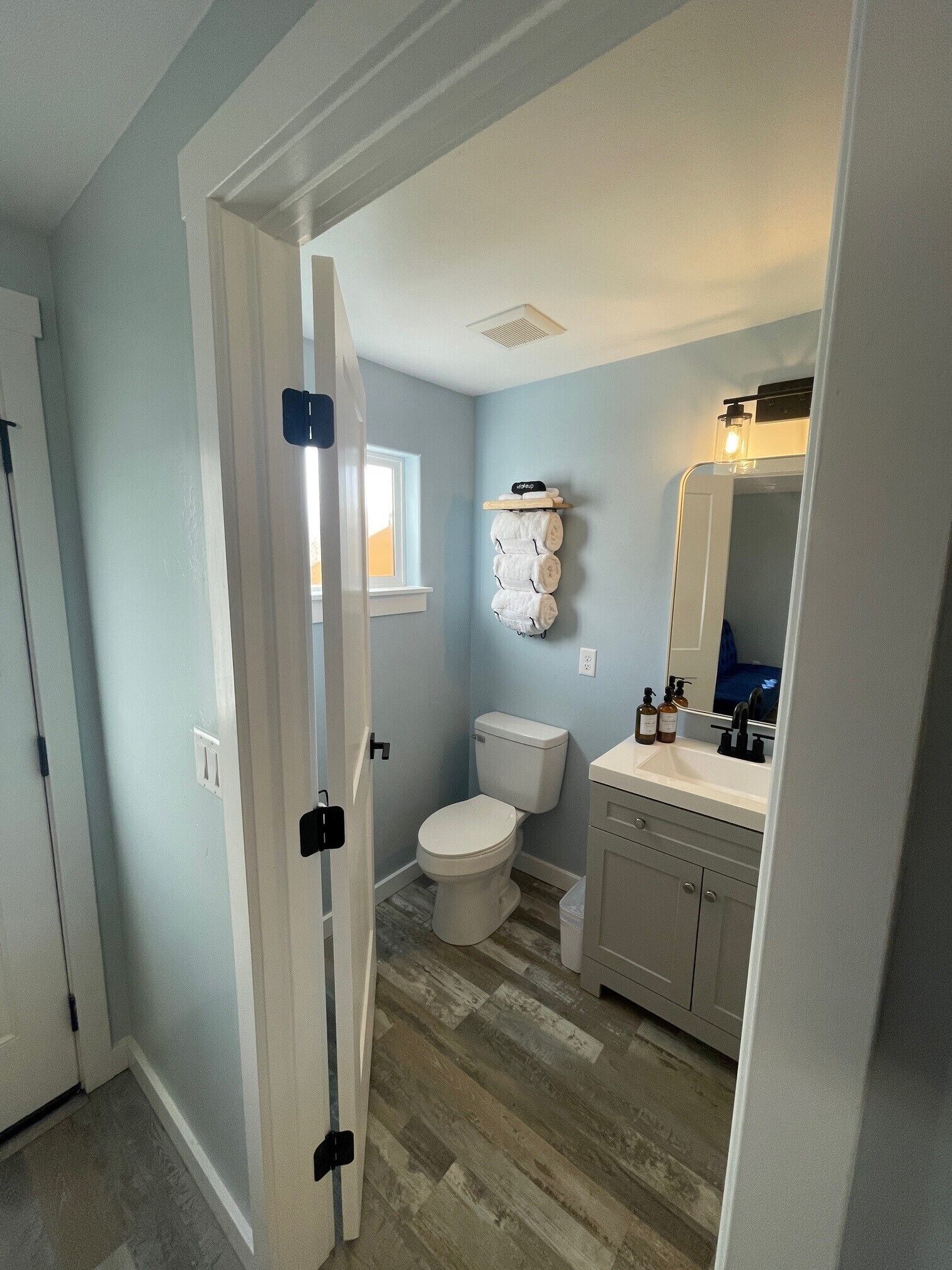 Une salle de bain avec des toilettes, un lavabo et un miroir.