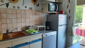 A compact kitchen with a sink, a coffee maker, a microwave, and a refrigerator. - Central Apartment near Beach with Balcony & Parking (Arcachon)