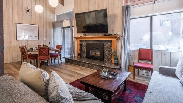 A cozy living room with a fireplace, a television, and comfortable seating. - Townhome on the Ski Back Trail! Fireplace! Shared Amenities! (Mammoth Lakes)