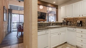 A modern kitchen with white cabinets, a granite countertop, and a built-in oven. - Townhome on the Ski Back Trail! Fireplace! Shared Amenities! (Mammoth Lakes)