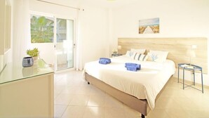 A bright hotel room with a large bed, a glass door leading to a balcony, and a painting on the wall. - Vacation home Inês by Interhome (Gale)