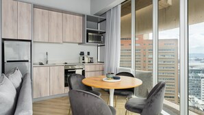 Eine moderne Küche mit Holzausstattung, einer Mikrowelle und einem Essbereich mit rundem Tisch und Stühlen.