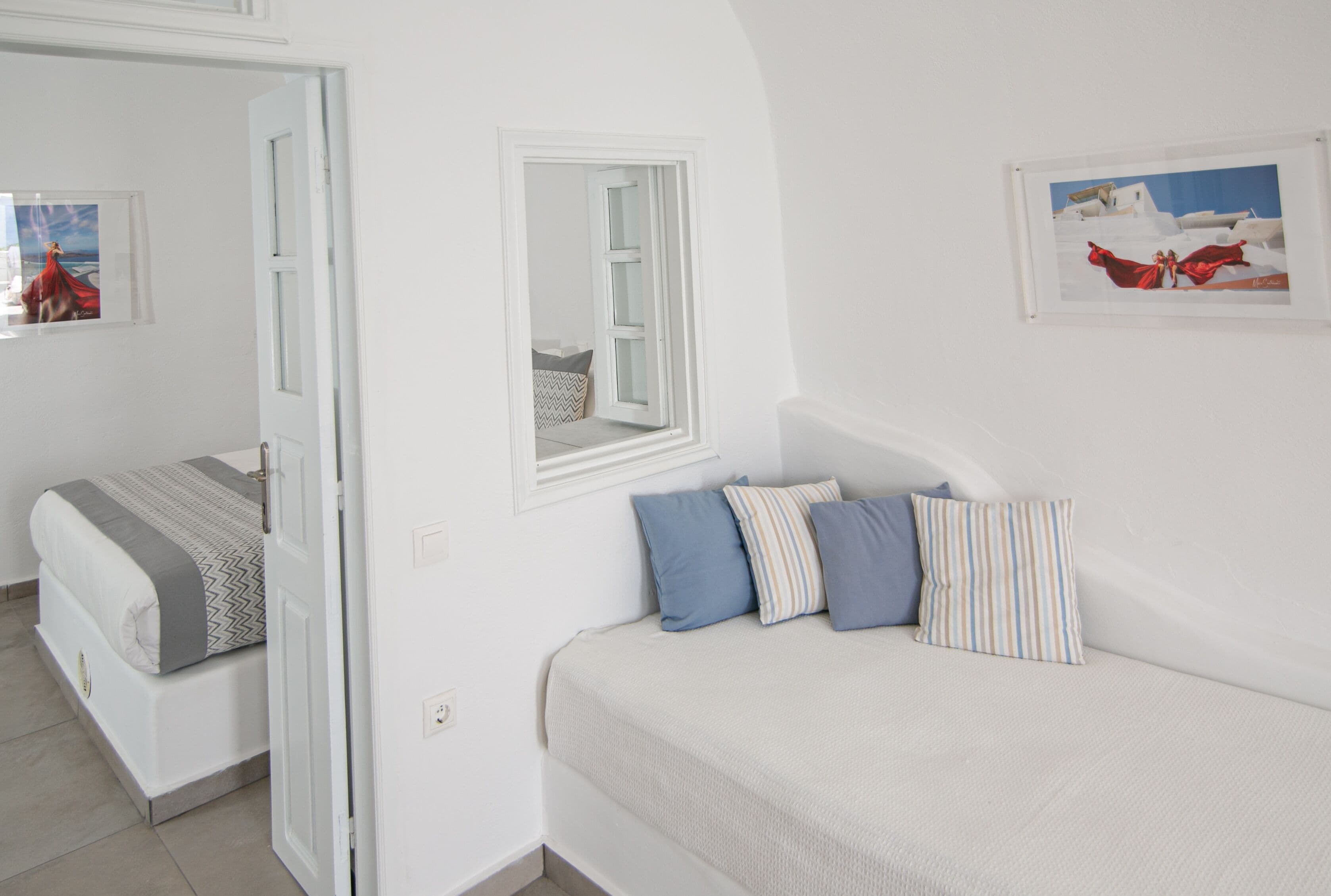 A bedroom with a bed, a window, and a door.