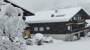Una casa a due piani con tetto innevato e facciata.