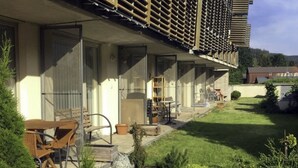 Un immeuble résidentiel doté d’un patio couvert, de mobilier d’extérieur et d’une pelouse bien entretenue.