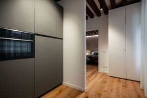 A modern kitchen with built-in appliances and a wooden floor.