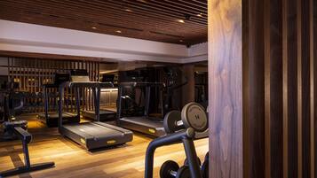 A gym with treadmills, elliptical machines, and weightlifting equipment.