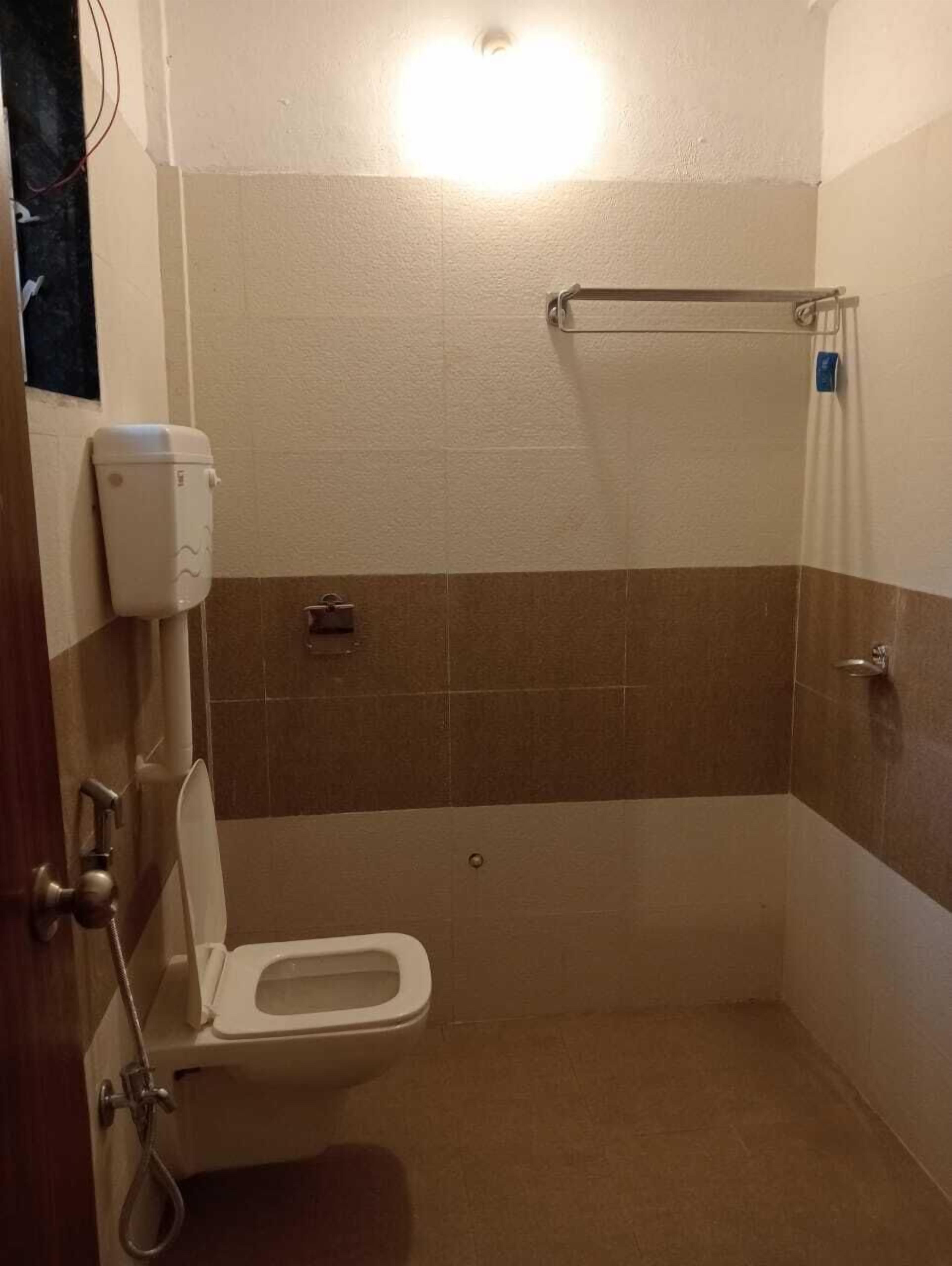 Un baño pequeño y estrecho con un inodoro, una ducha y un perchero para toallas.