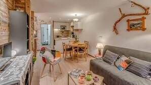 Ein modernes Wohnzimmer mit einer Couch, einem Couchtisch und einem Essbereich mit Stühlen und einem Tisch.