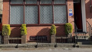 A two-story building with a sign for "Alexander Hotel" and a phone number. - Alexander Hotel (Blackpool)