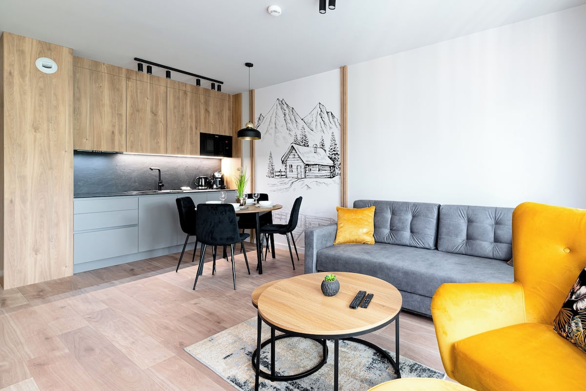 A modern apartment with a kitchen, dining area, and living room.