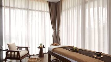 Una habitación con una cama, una silla y una mesita con una planta.