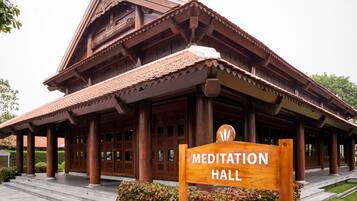 A wooden building with a sign reading "Meditation Hall".